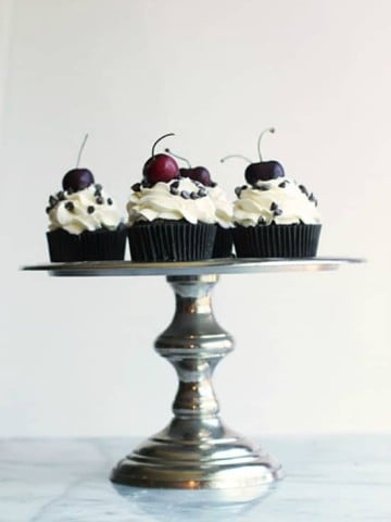 Chocolate cupcakes studded with chopped cherries and topped with fresh whipped cream and more chocolate.