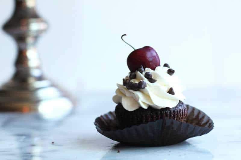 Chocolate cupcakes studded with chopped cherries and topped with fresh whipped cream and more chocolate. 