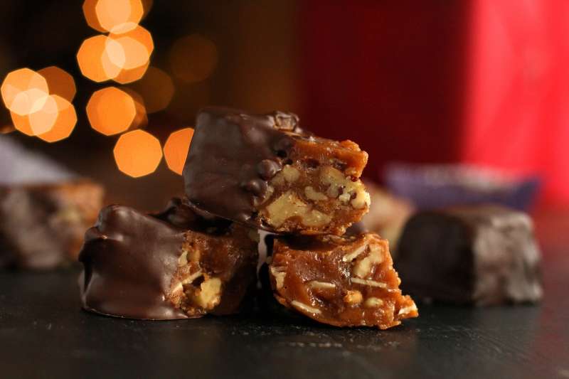 Side Shot of a piece of California brittle with nuts and caramel layers exposed. 