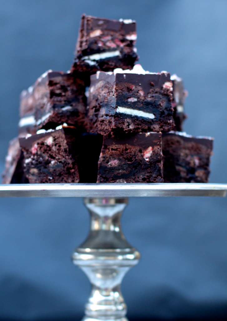stacked chocolate peppermint Brookies bars on a tall metal cake plate.