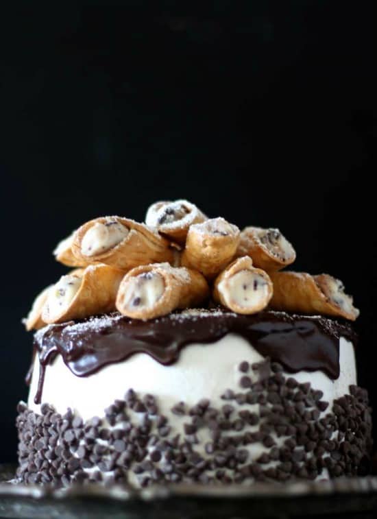 Layered cake with rich ricotta cannoli filling topped with an italian buttercream and homemade mini cannolis