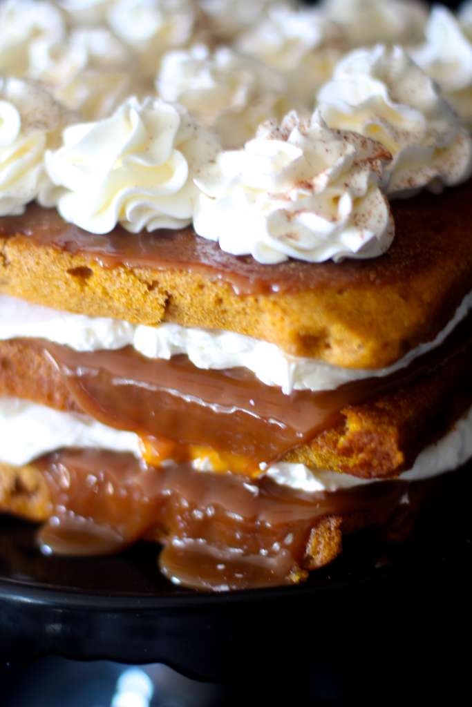 Up close photo of the square naked cake with caramel oozing out. 