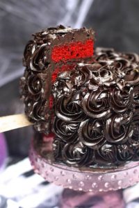 A delicious red velvet Halloween cake that is blood red and topped with black roses will keep the ghouls and goblins happy this year!