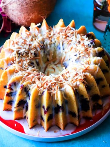 Coconut blueberry lime bundt cake on red plate feature image.