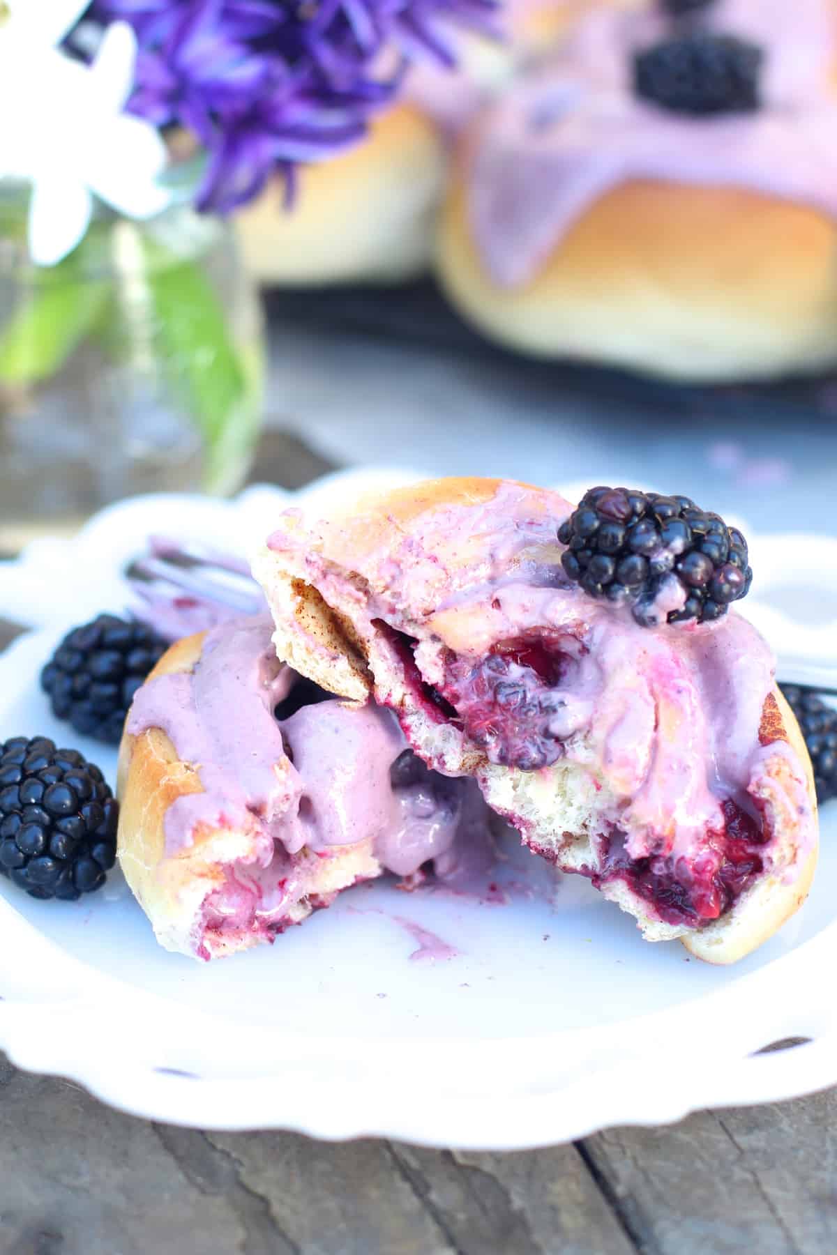Soft sweet rolls with cinnamon and fresh blackberries topped with cream cheese blackberry icing