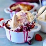 Blueberry, blackberry, and raspberry summer cobbler topped with buttery delicious cakey topping sprinkled with cinnamon and sugar