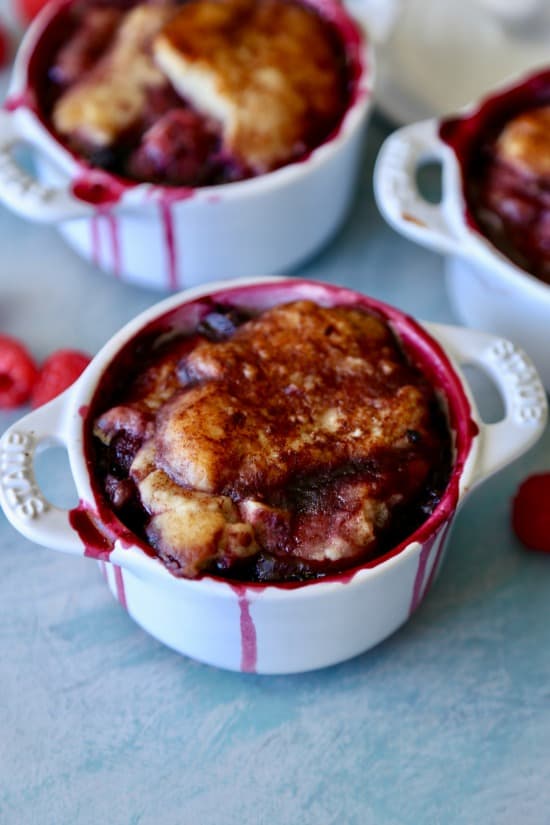Blueberry, blackberry, and raspberry summer cobbler topped with buttery delicious cakey topping sprinkled with cinnamon and sugar