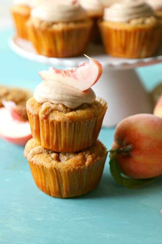 Cinnamon bourbon cupcakes with fresh peaches and a brown sugar streusel topping. Topped with a sweet bourbon peach cinnamon frosting.
