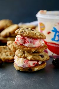 Soft and chewy white chocolate chip cookies studded with dried cherries that sandwich cherry cheesecake ice cream