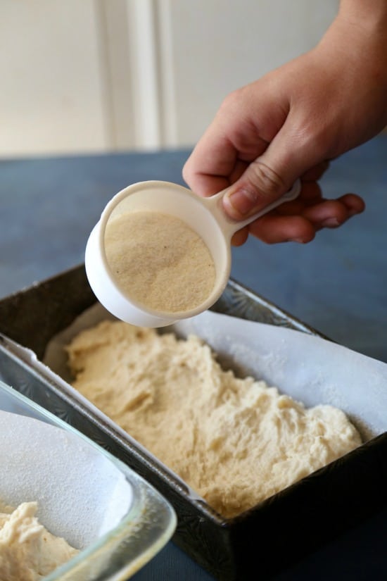 sprinkling cornmeal over english muffin bread dough