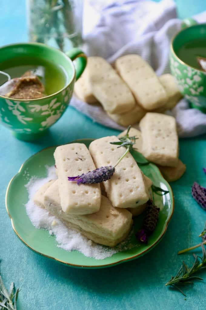 Lavender Shortbread cookies on green plate with a cup of tea in background