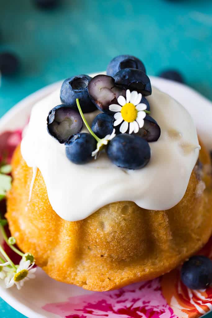 mini blueberry bundt cakes overhead view with fresh blueberries and a flower on top
