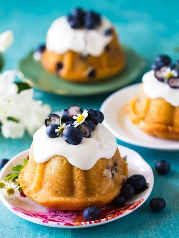 three mini blueberry bundt cakes on individual serving plates
