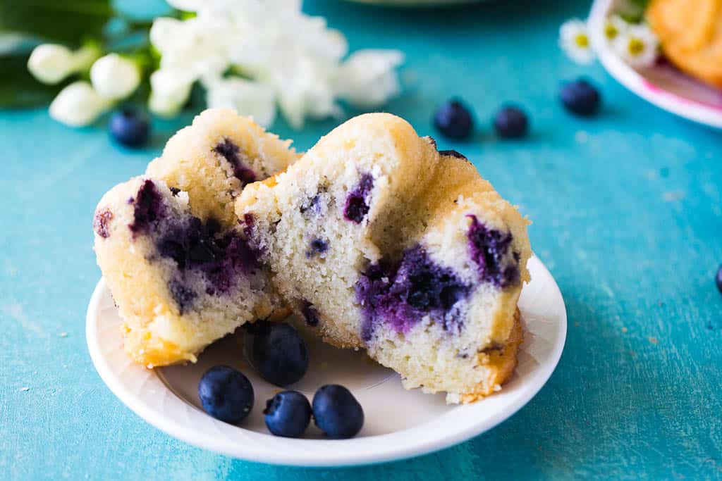 mini blueberry bundt cakes cut in half on a white plate