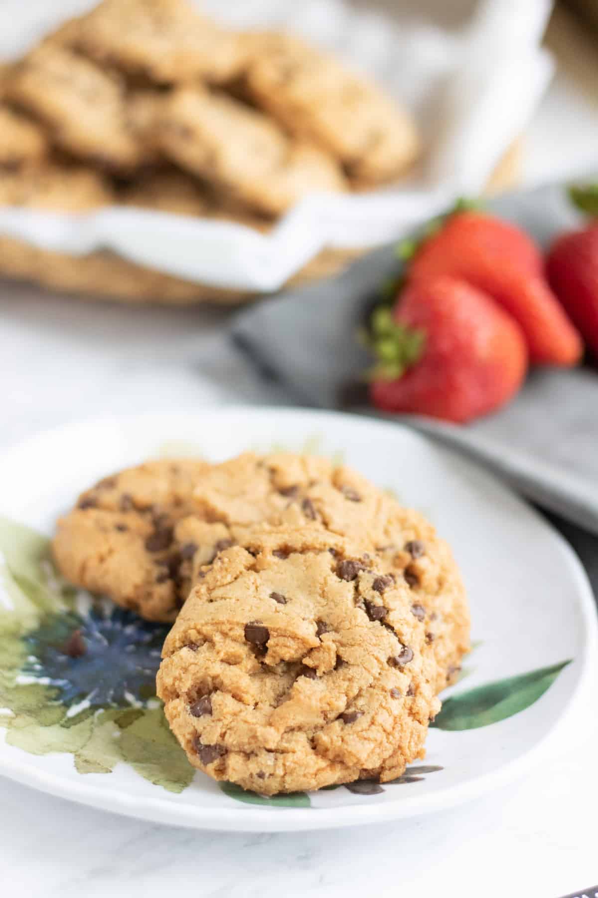 closeup of chocolate chip strawberry cookies on a plate with another basket in the background