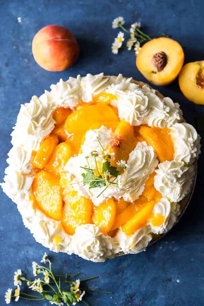 overhead view of fresh peach pie surrounded by raw peaches