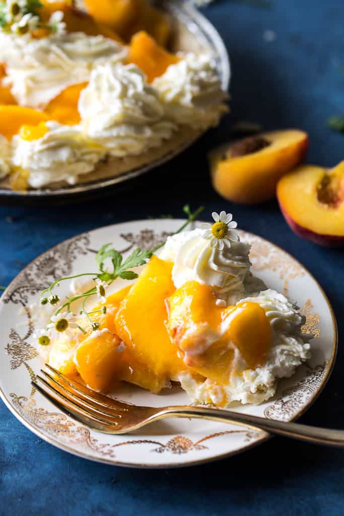 Fresh Peach Pie slice on a plate next to a gold fork