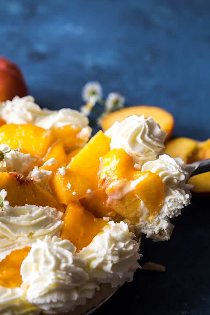 Fresh Peach Pie slice being pulled out of full pie