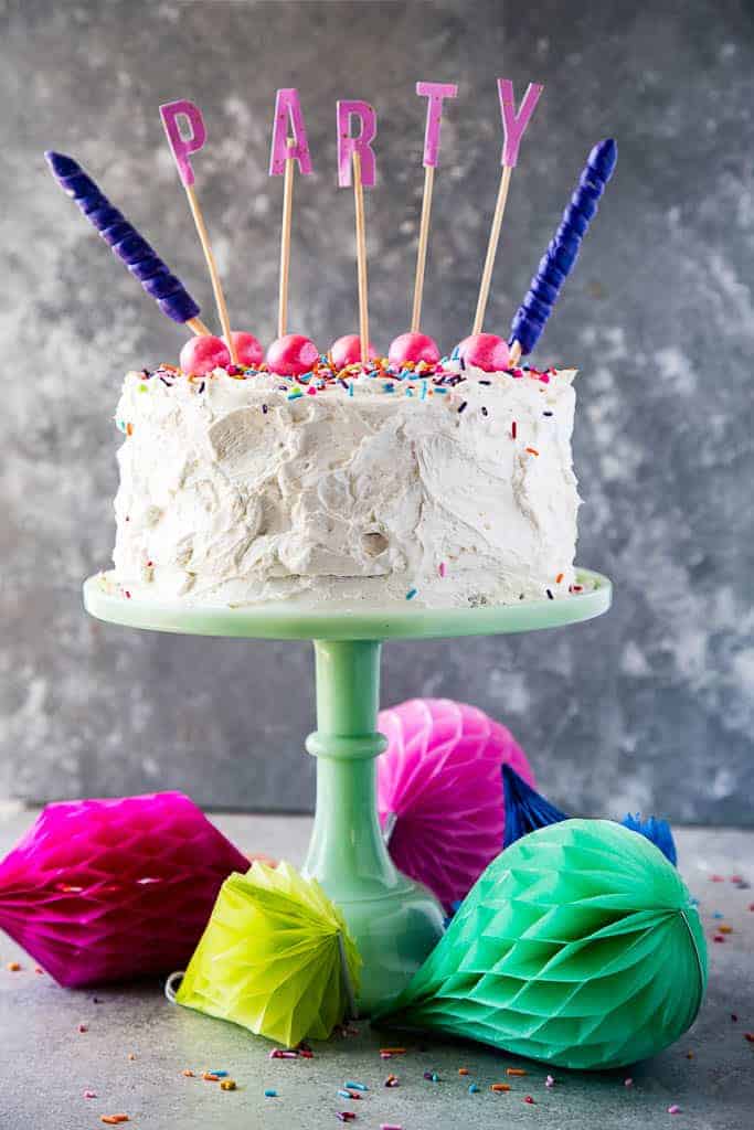 funfetti cake on a green cake stand with PARTY text on the top