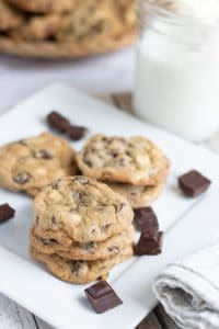 Triple Chocolate cookies on a white plate next to a glass of milk