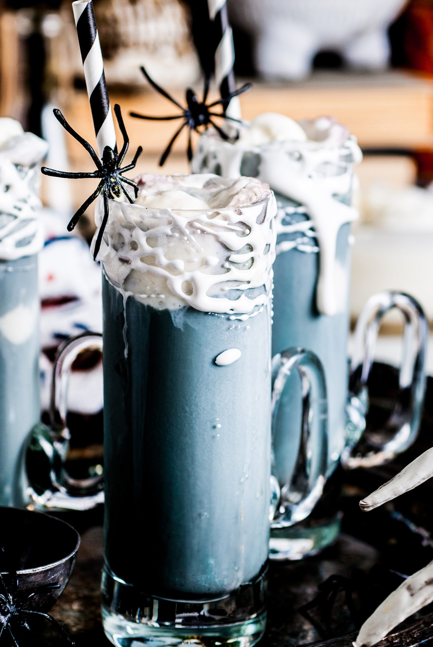 Photo of 3 grey root beer floats with marshmallow string immediately glasses. 