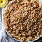 Apple buttermilk pie with oatmeal streusel topping on a beige dish towel