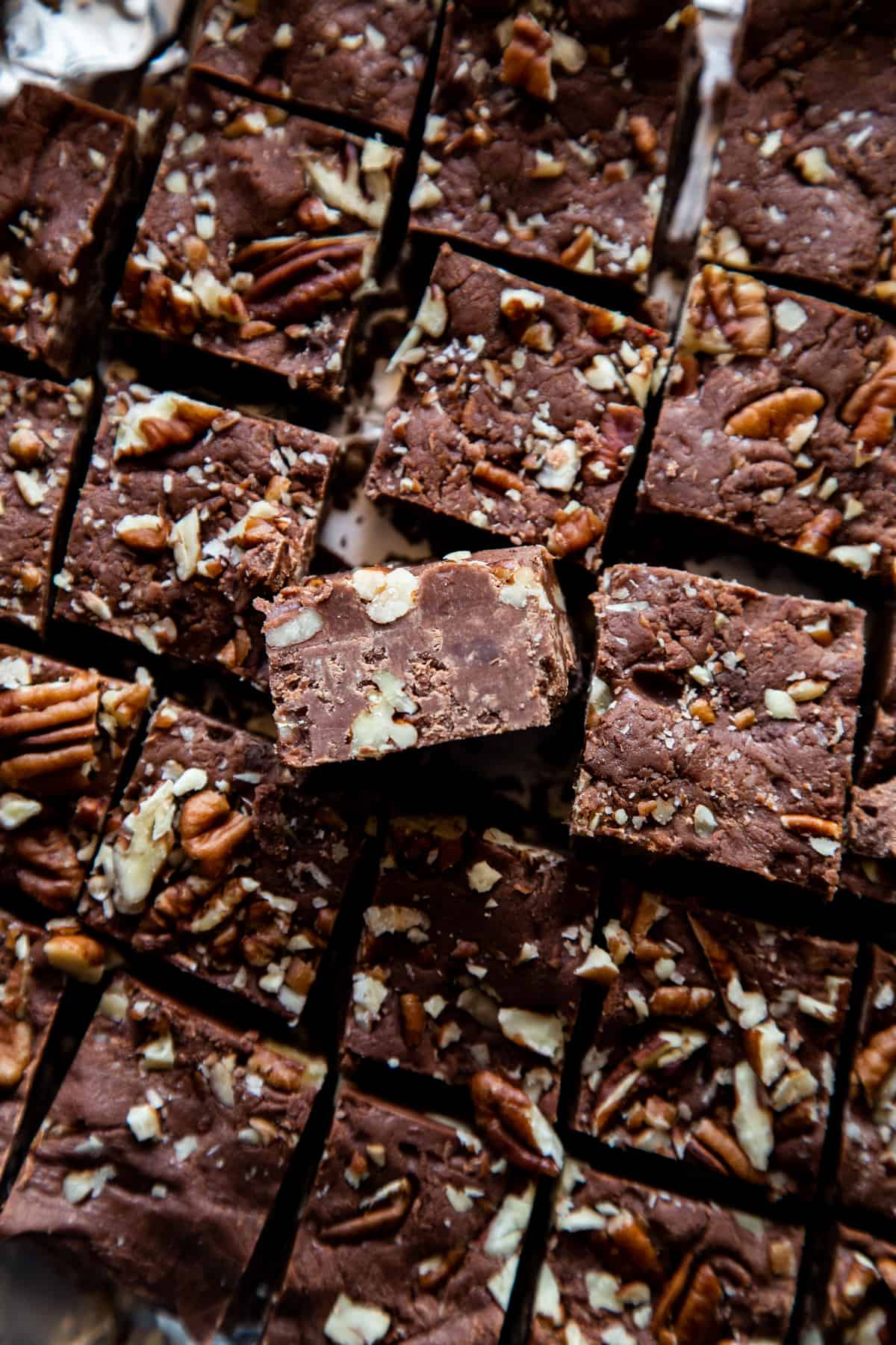 overhead shot of a batch of fudge cut into squares showing the pecans. 