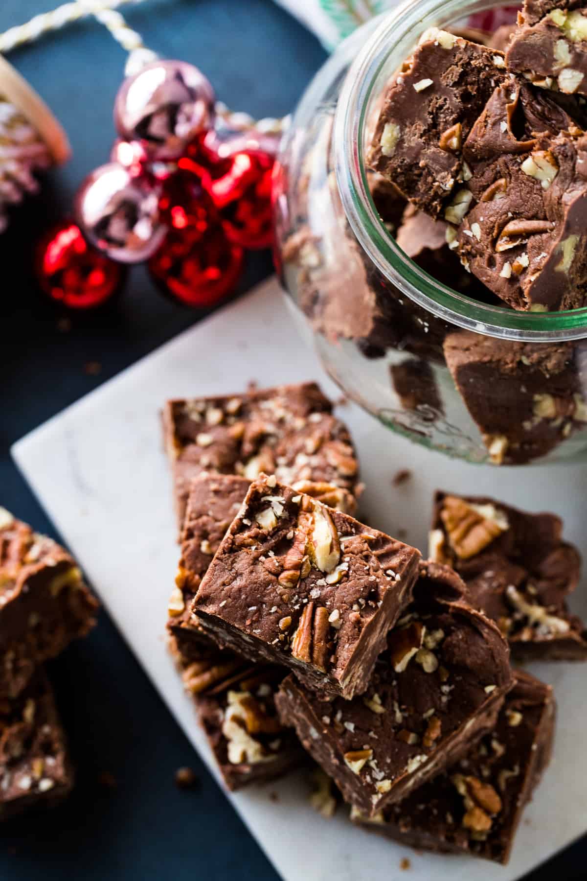 Overhead shot of the fudge in a round jar and pieces on a marble plate. 