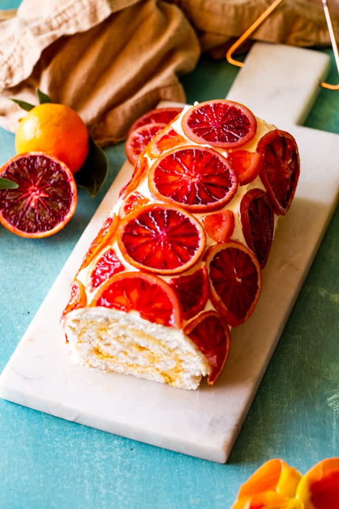 Side shot of the blood orange roulade with candied orange slices. 