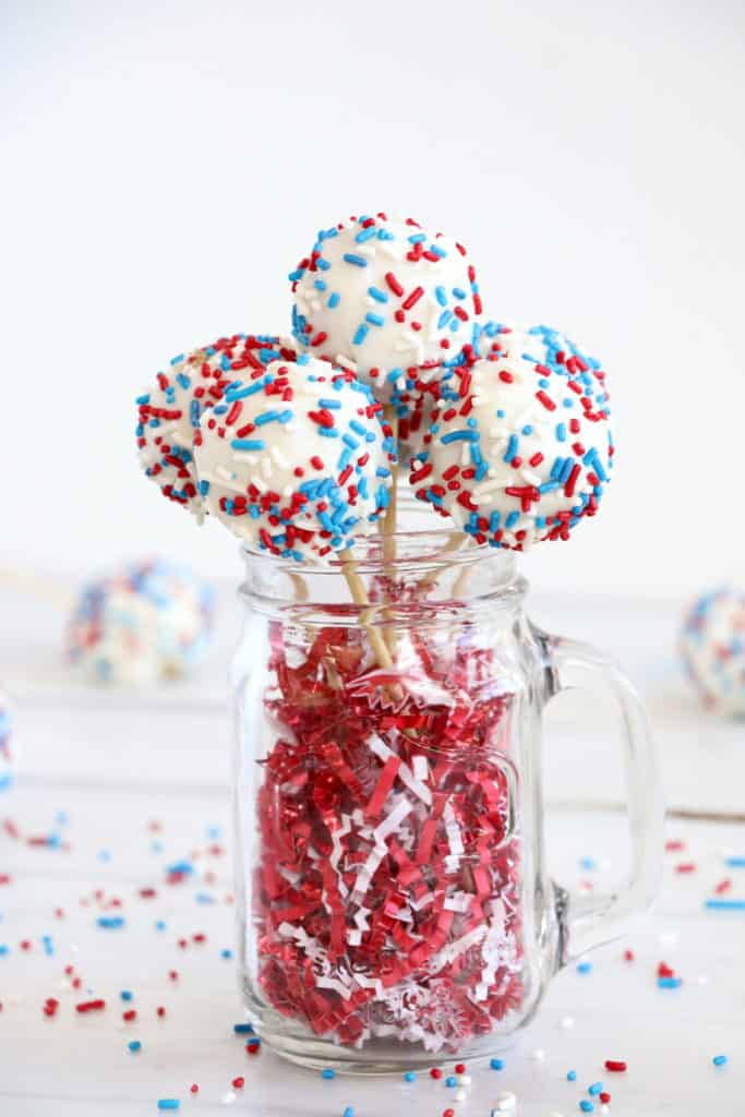 red white and blue cake pops served in a mason jar mug