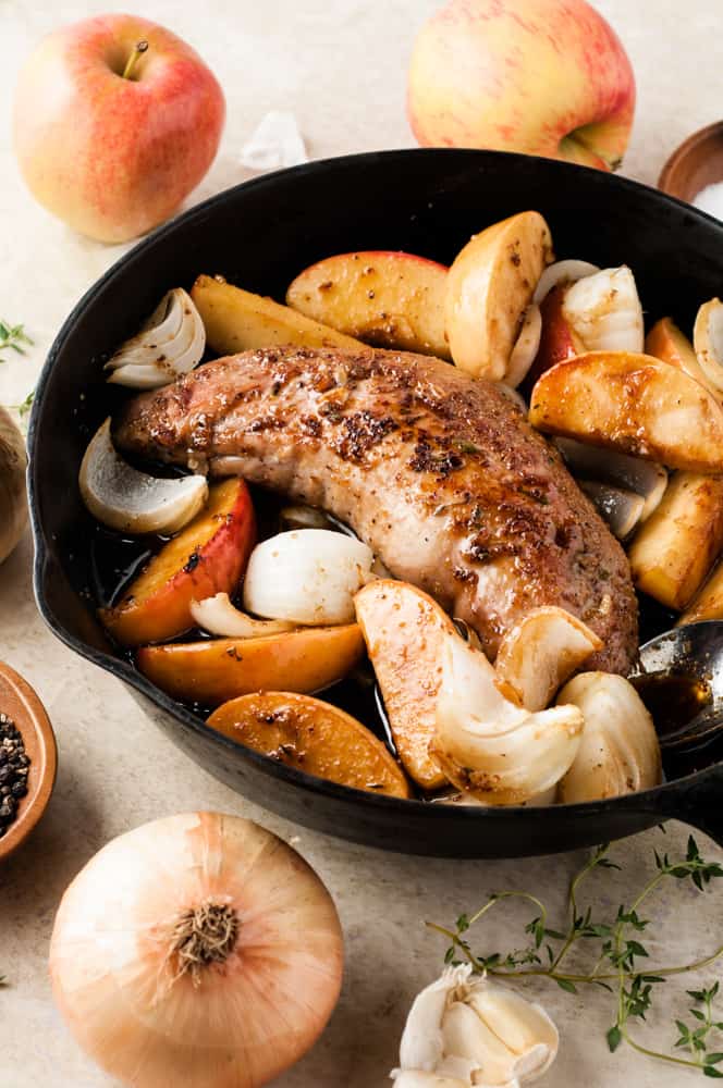 cooked pork tenderloin with apples in pan