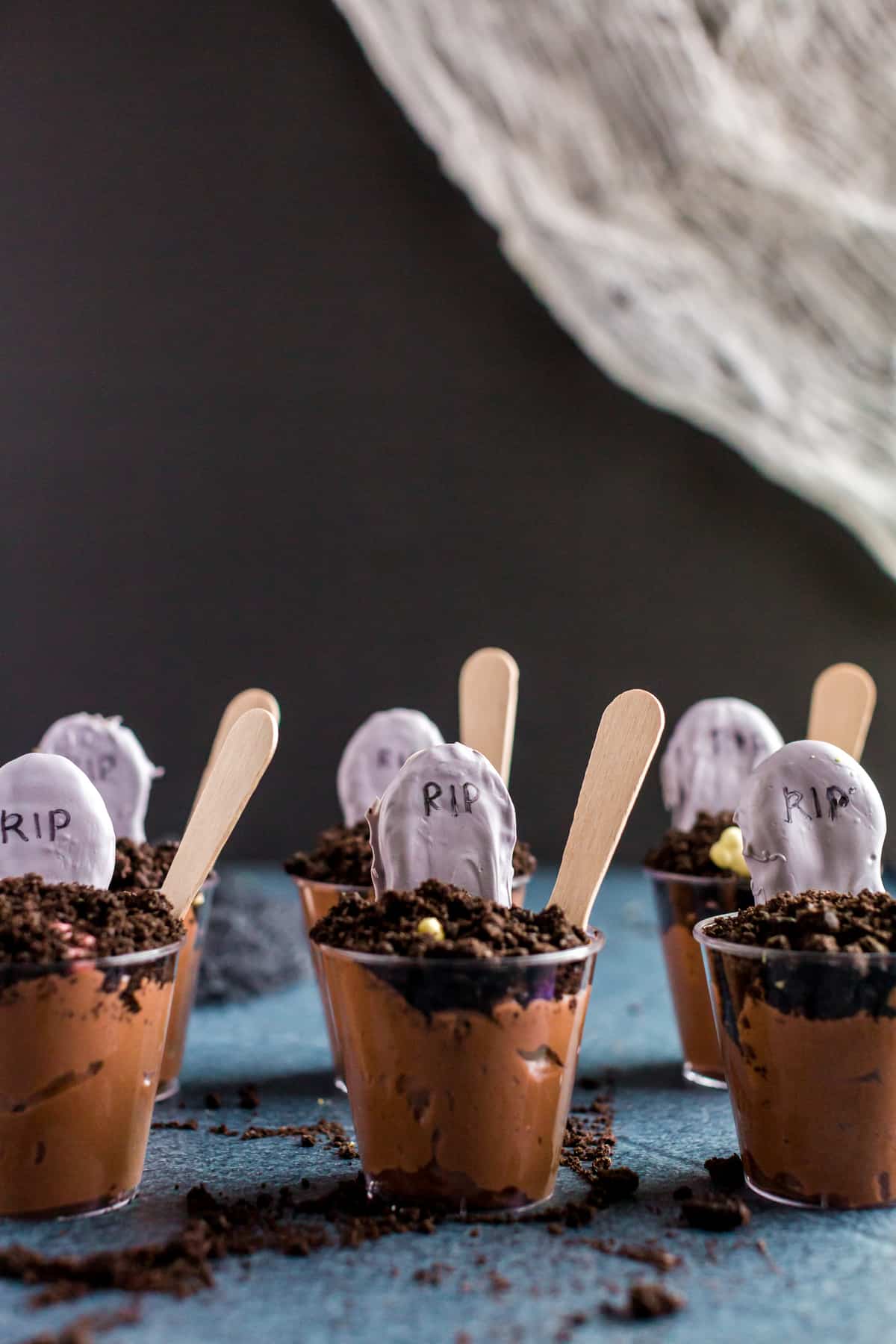 Cups lined up next to each other with spoons on a black backround.