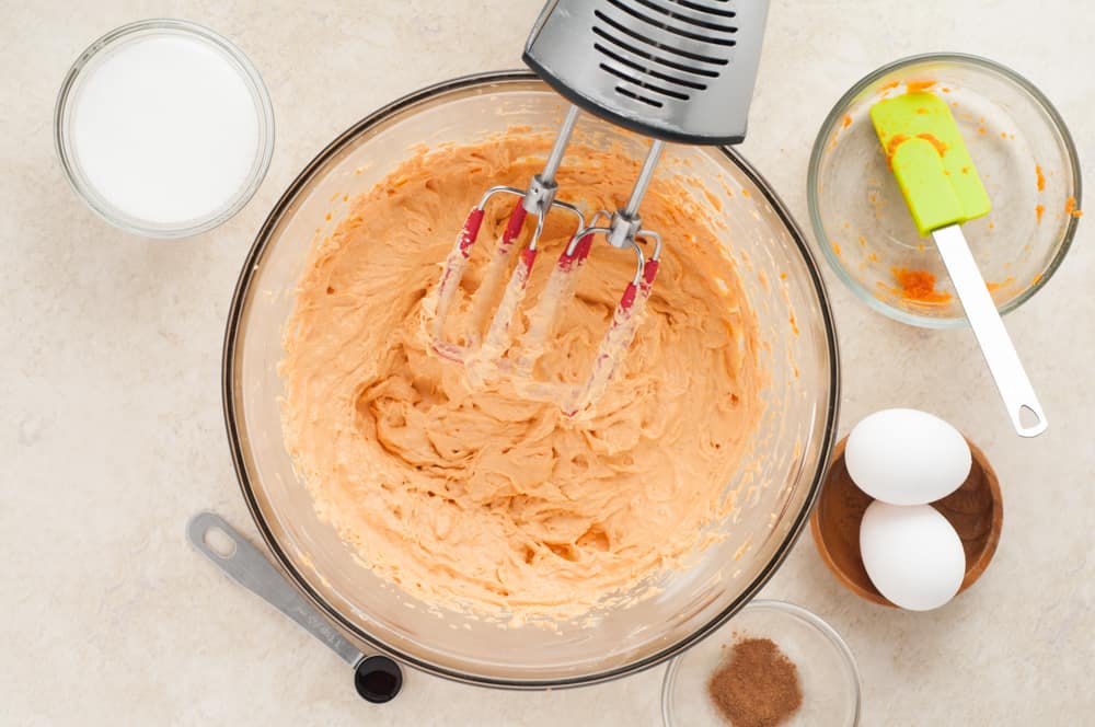 making the pumpkin batter with beaters for cheesecakes