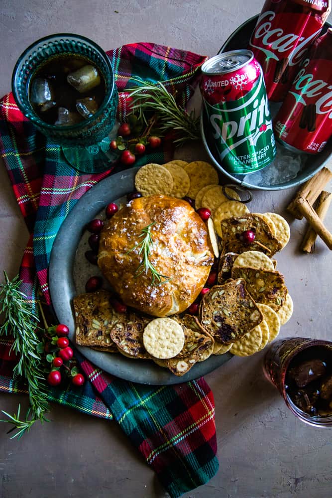 cranberry baked brie on plate with crackers and soda