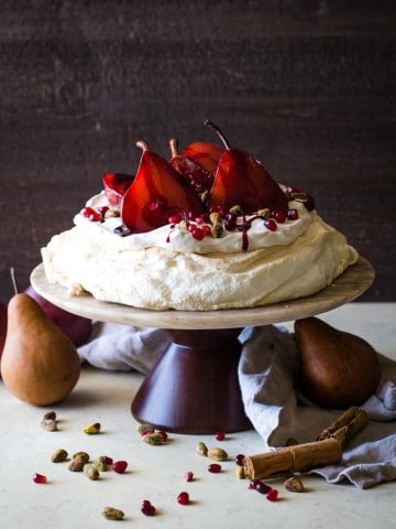 cake stand with pavlova with pomegranate pears