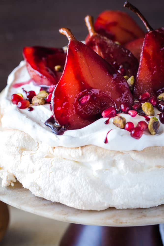 close up shot of pavlova with pomegranate pears