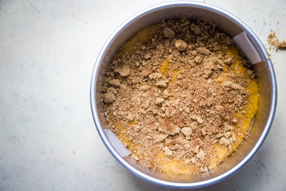 pumpkin coffee cake batter in pan with streusel