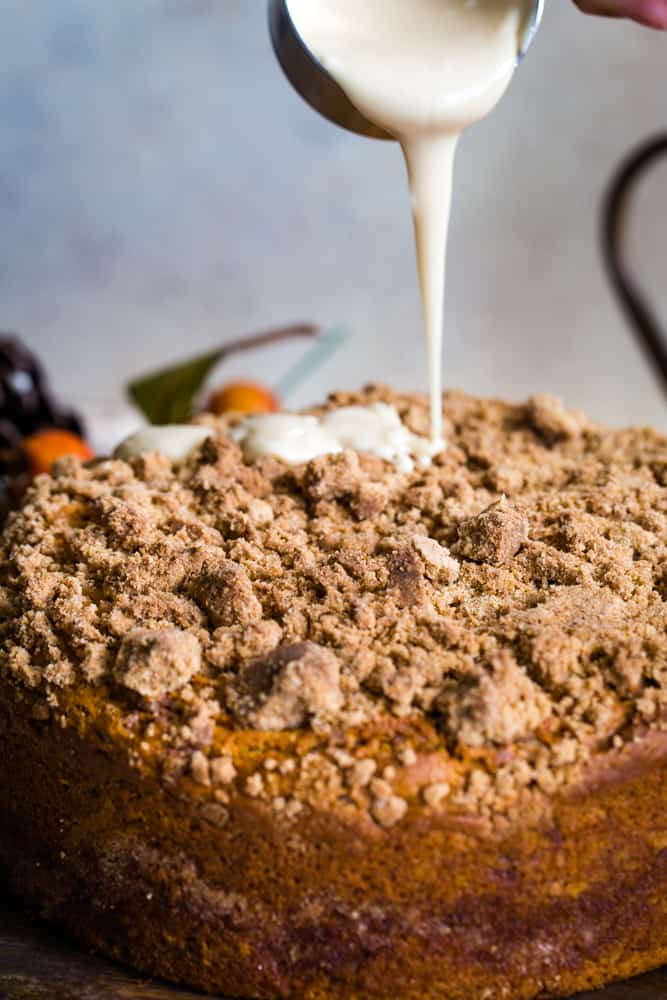 pouring maple glaze onto pumpkin coffee cake