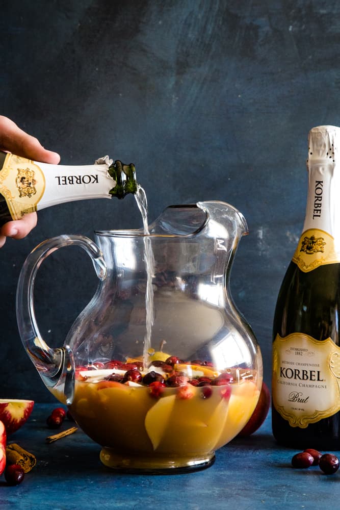 pouring korbel champagne into pitcher with fruit