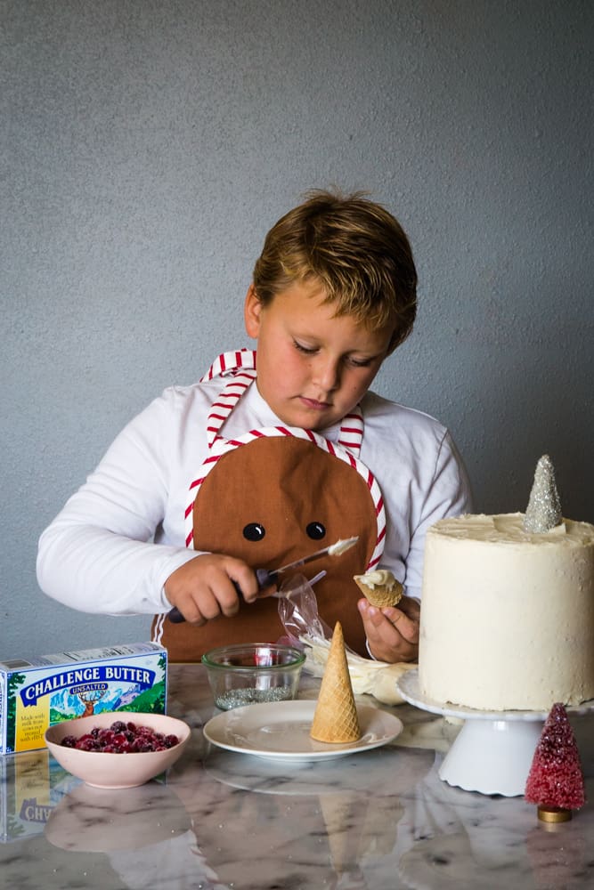 boy decorating cranberry christmas cake