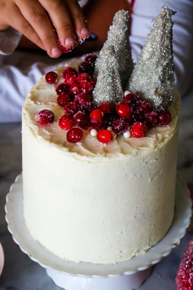 adding sprinkles to the cranberry christmas cake