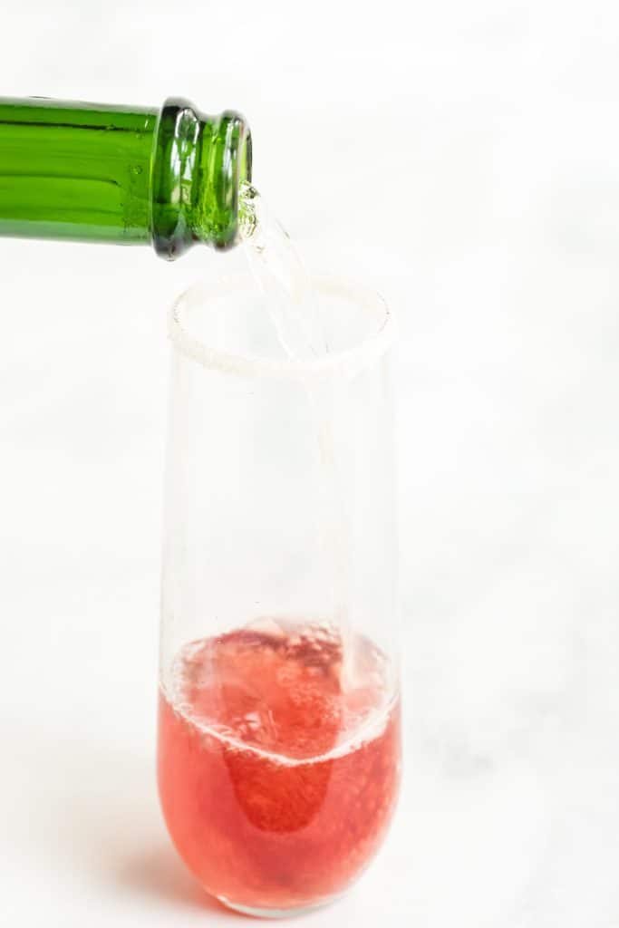 adding champagne to cranberry juice