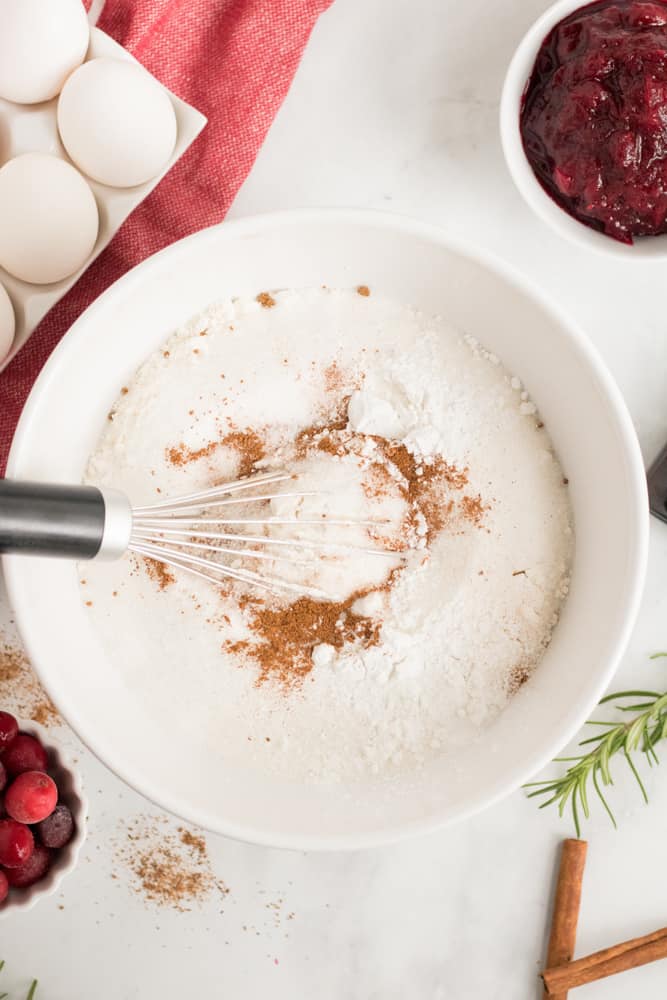 Mixing together the dry ingredients in a large white bowl with whisk. 