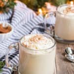 cup of eggnog recipe in two glasses with Christmas tree in background