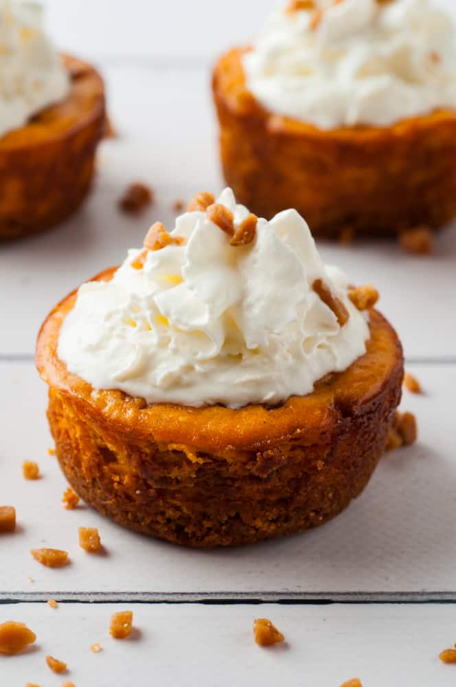 mini pumpkin cheesecakes on a wood panel