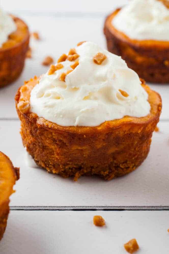 mini pumpkin cheesecakes on white wood board