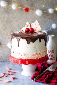peppermint bark layer cake on red and white cake stand
