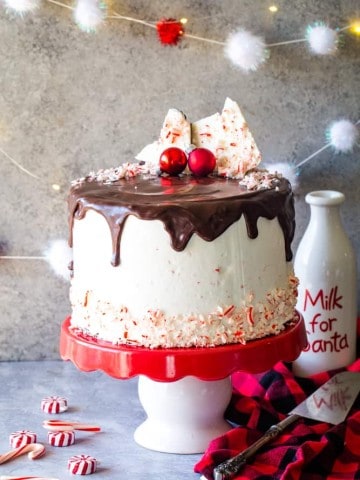 peppermint bark layer cake on red and white cake stand