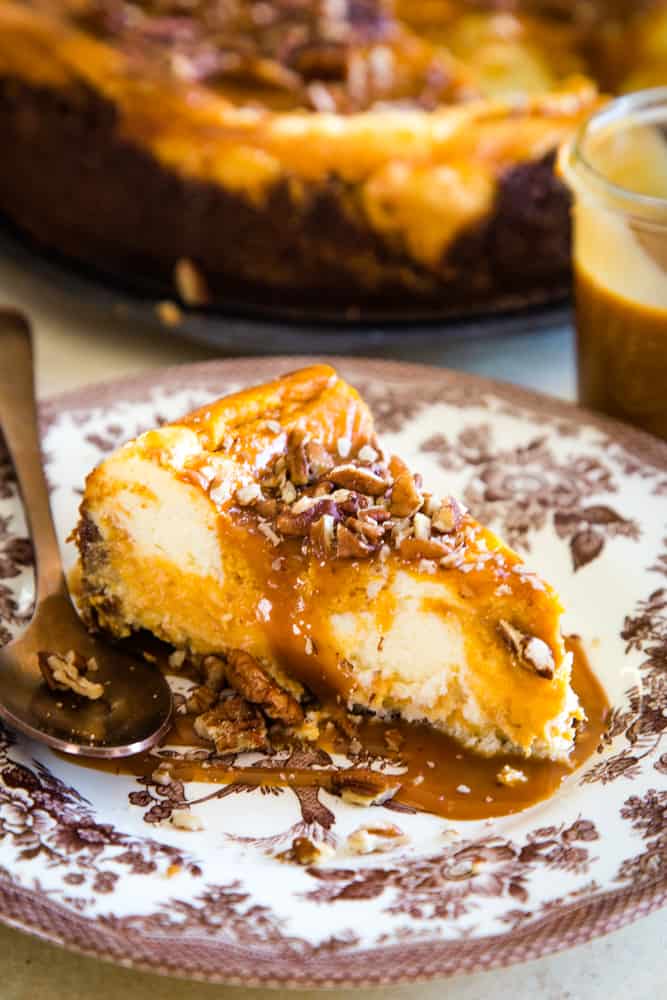 slice of sweet potato swirled cheesecake on brown plate with spoon