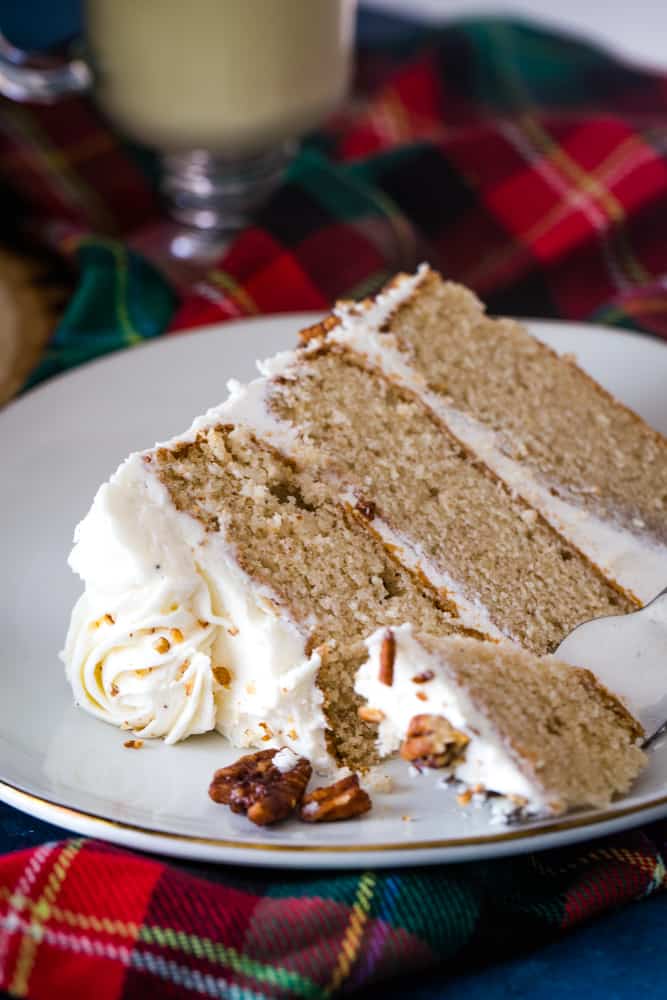 slice of eggnog layer cake with fork on white plate